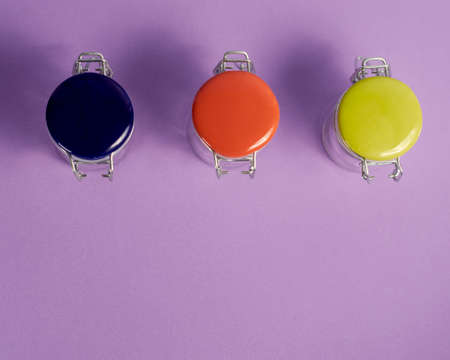 Glass jars with colored ceramic and metal lids.の写真素材