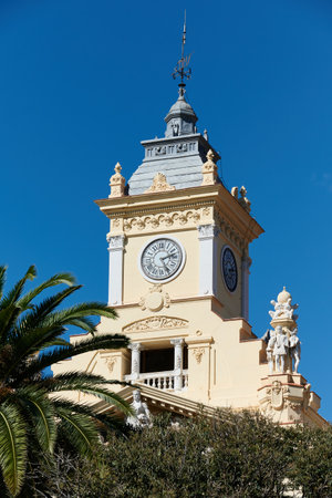 Malaga City Hall clock tower with trees surrounding the architectural building.