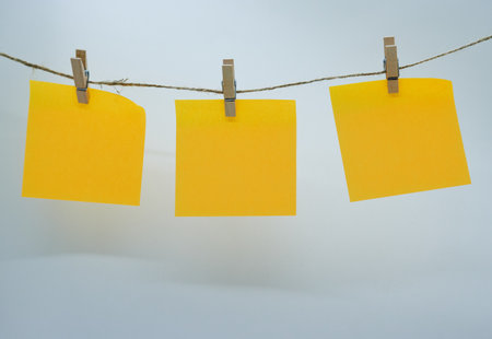 Post-its hanging with wooden clothespins on a rope.