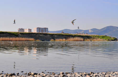 The city on the seashore is reflected in the mirror of sea water.