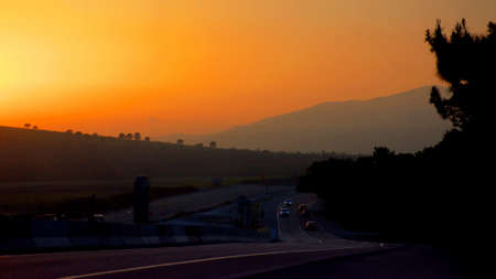 The motorway at sunset. The road rushes after the departing sun. Pink evening sky.