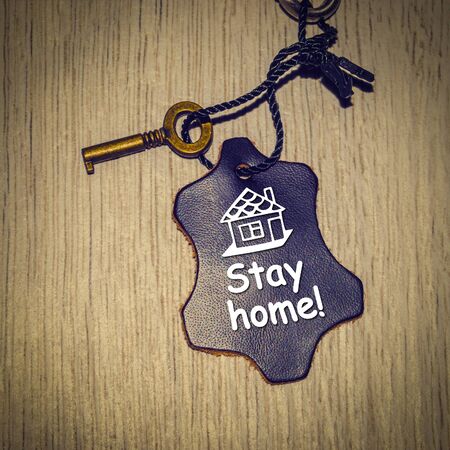 Stay home! A piece of genuine leather in blue and a golden key.