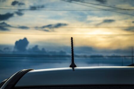 Car radio antenna on a car roof. Sunsetの写真素材