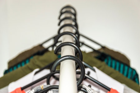 White Rack clothes hanger, black plastic hangers.