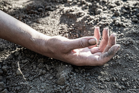 Dirty female hand lies on the ground.の写真素材