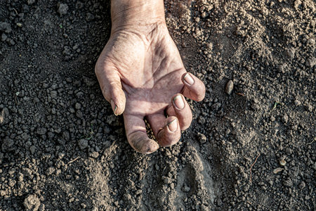 Dirty female hand lies on the ground.の写真素材