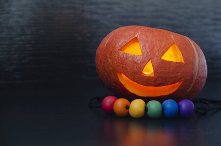 pumpkin carving jack lantern head orange halloween, lgbt beads on a black background. copy spaceの写真素材