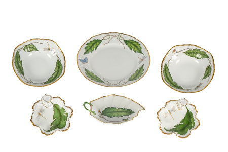 Set of porcelain plates with green leaves isolated on white backgroundの写真素材