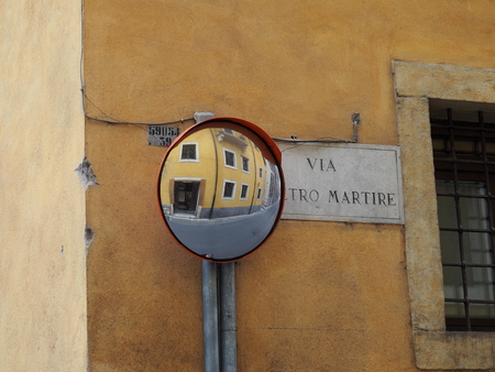 Yellow traditional buildings in the historic centre of Verona, reflected in a traffic mirrorの写真素材
