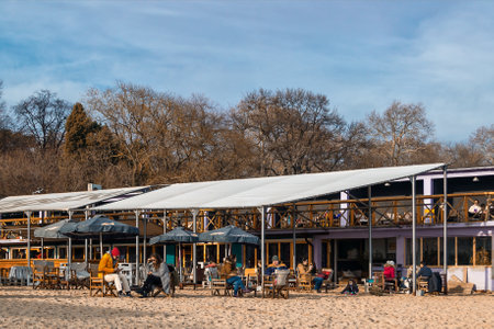 Bulgaria, Varna, December 22, 2018. People relax in a coastal cafe on a sunny winter day. View of the outdoor cafe on the sea beach in winter.のeditorial素材
