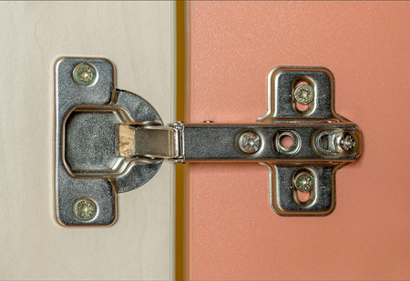 Furniture fittings for fixing cabinet or wardrobe doors close up. Modern accessories for wooden...