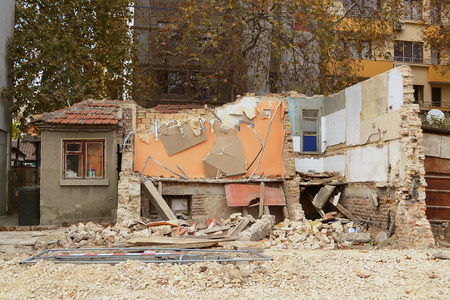 Demolition of an old two-story residential building in the city, half the building is already destroyedの写真素材