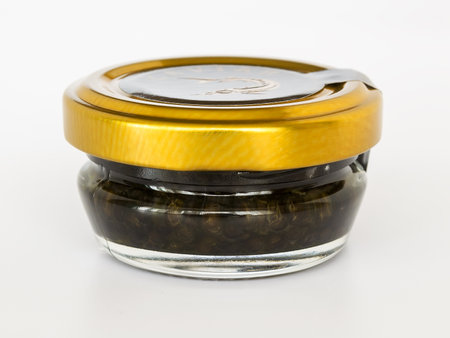 Varna, Bulgaris, March 27, 2019. Black caviar in a glass jar with a golden lid on a white background. Sturgeon caviar, fish delicacy.のeditorial素材