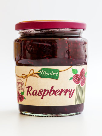 Varna, Bulgaria, April 17, 2019. Close-up of glass jar with raspberry jam produced by Maribel company for supermarket chain Lidl. sweet berry jam pot on white background.のeditorial素材