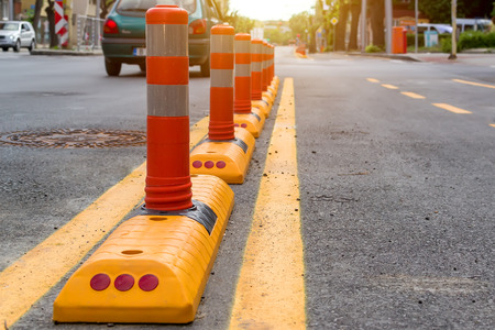 Columns with a reflective layer and yellow road marking separates the cycle path from the automobile...