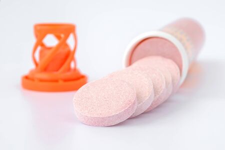 Soluble effervescent vitamin tablets spilled out of a plastic bottle on a white background. Vitamins and nutritional supplements. Health care and medical. Front view.の写真素材