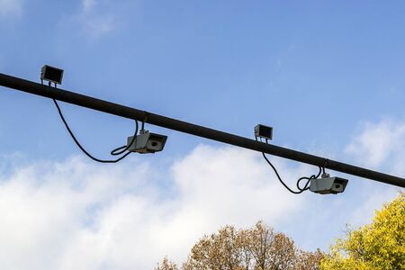 Two pairs of outdoor surveillance camera with sensor installed on a pole above a roadway. Modern...