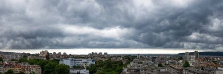 Panorama of dark thunderstorm sky hovering over Varna. Dramatic cloudscape over seaside city. Scenic...