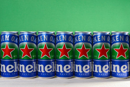 Varna, Bulgaria, October 09, 2020. Row of Heineken 0.0 beer cans with red star on a white wood table against green wall. Nonalcoholic malt lager in aluminum cans with pull tabs. Front view.のeditorial素材
