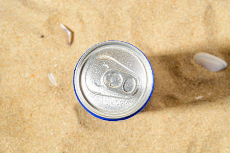 Water drops on a cold beer or soda can top agains sea sand on a sunny day. Drinking on the go beverages in aluminum cans with pull tabs. Copy space. Top view.の写真素材