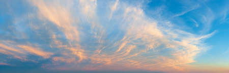 Majestic vanilla sky at evening. Azure sunset heaven with golden pink cirrus clouds over the horizon. Panoramic shot of pastel colored skyscape. Beauty in nature.の写真素材