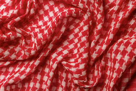 Draped shemagh of red white colors background. Arab desert scarf hirbawi texture. Folded cotton...