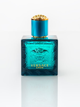 Varna, Bulgaria, December 25, 2021. Versace Eros perfume in a rectangular blue glass bottle on a white background. Stylish men perfume produced by Gianni Versace luxury fashion company. Front view.のeditorial素材