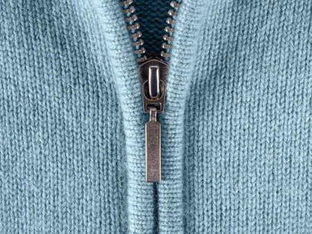 Zip fastener of cashmere sweater macro. Fashionable blue jacket with zipper fastening for cold...