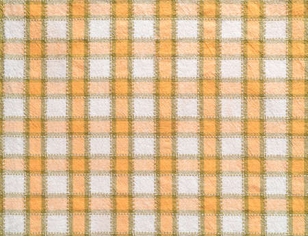 Checkered cotton fabric background. Macro texture of white orange kitchen towel. Detail of cloth...