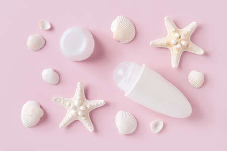 Roll on deodorant antiperspirant, sea stars and shells over pastel pink background. Sea minerals...