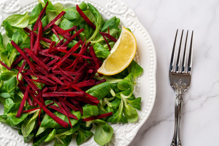 Lambs lettuce with raw beet vitamin salad. Grated raw beet over fresh cornsalad leaves and lemon...