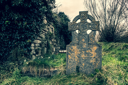 Ireland celtic cross at medieval church cemetery Old spooky cemetery. Haunted cemetery. Scary place. Old gravesの写真素材