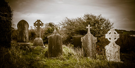 Ireland celtic cross at medieval church cemetery Old spooky cemetery. Haunted cemetery. Scary place. Old gravesの写真素材