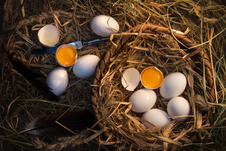Chicken eggs homemade white and beige are in a wooden basketの写真素材