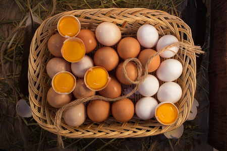 Chicken eggs homemade white and beige are in a wooden basket.の写真素材