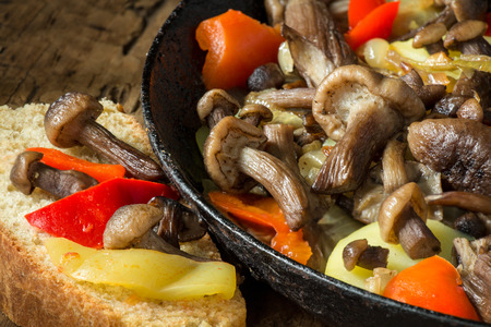 Mushrooms fried with onions and potatoes in the pan.の写真素材