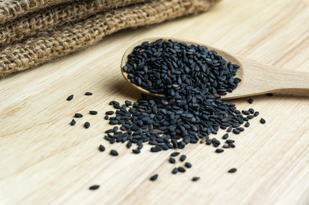 Close up black sesame in wooden spoonの写真素材
