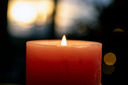 Burning candle on the background of the night city. Close-up.の写真素材