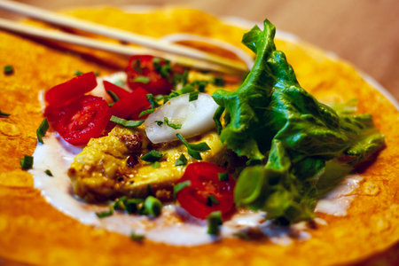 Tortilla with egg and vegetables on a wooden background. Toned.の写真素材