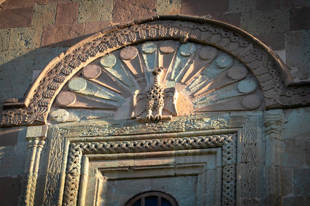 Stone relief of a stylized eagle or phoenix on the facade of a Georgian Orthodox church in Mtskheta....