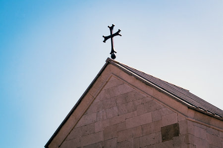 Cross on the roof of the church against the blue sky. Religious symbol.