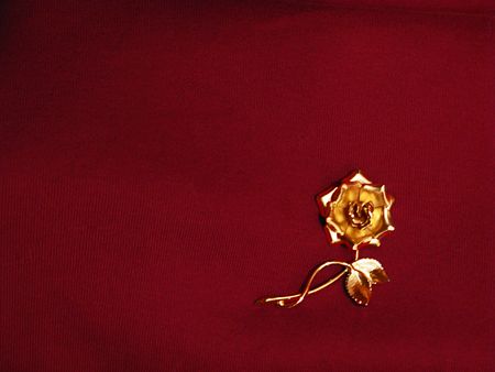 Gold metallic rose resting on a deep red sweater--perfect for your Valentine message.の写真素材