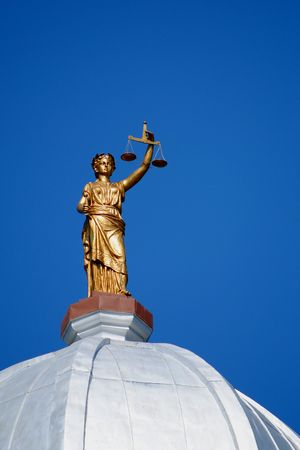 Justice holds her scales aloft to the blue heavens, poised atop a courthouse dome in Iowa, USA..の写真素材