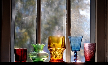 Collection of vintage glassware on the shelf in the window of the old house の写真素材