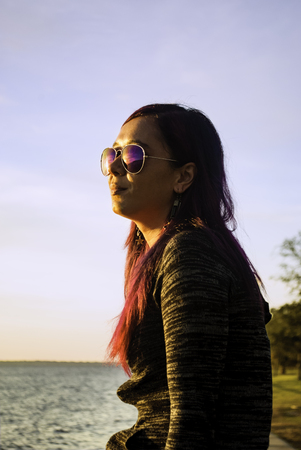 Woman watching sunrise over the bay.の写真素材