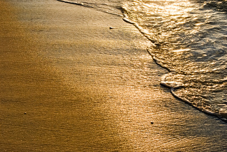 Sunrise turns the waves to liquid gold.の写真素材