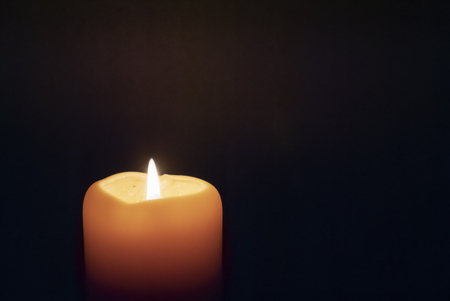 White candle shining in the darkの写真素材