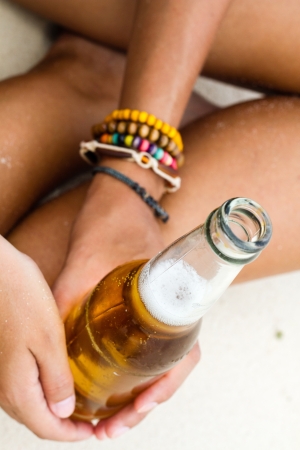 woman with beer on beachの写真素材