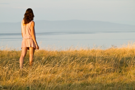 young woman in dress looking to the seaの写真素材