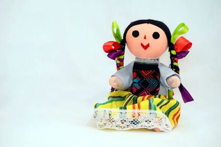 Traditional doll, made by Mexican indian ladies out of cloth, threads and ribbons, wearing colorful outfit and braided dark hair. Classic toy for children in Mexico and bought by tourists as souvenirs.の写真素材